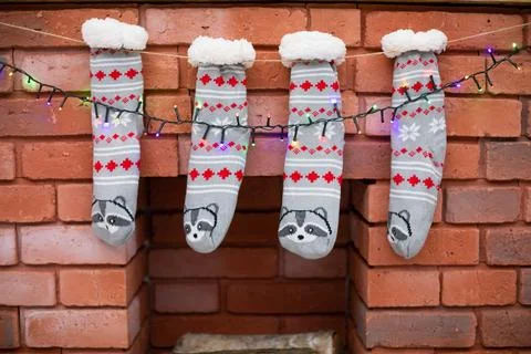 Decorated bricks fireplace with gray socks and Christmas lights. Foto stock