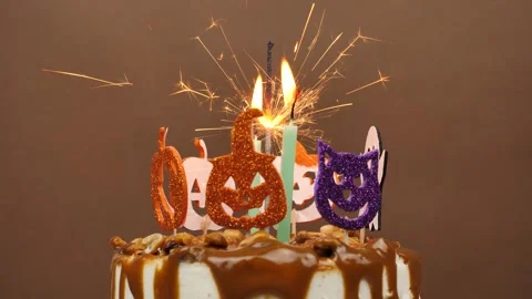 Decorated cake in Halloween style. Pumpkin theme with candles and sparkler on Stock Footage 242178992