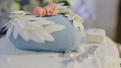 Decorated cake for newborn baby on table with baby doll decorated on top Stock Footage 128685779