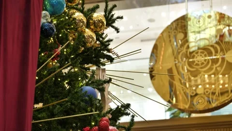 A decorated Christmas tree against the backdrop of a swinging clock pendulum. Vídeos de archivo 348516099