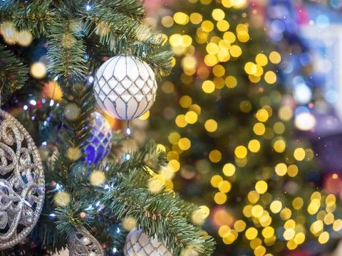 Decorated Christmas tree on the background of soft yellow lights with bokeh e Stock Photos
