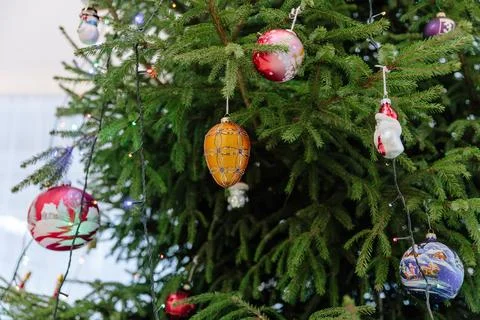 Decorated Christmas tree branches featuring a central golden patterned glass Stock Photos