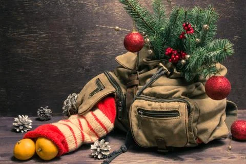 Decorated Christmas tree in canvas backpack on wooden background Stock Photos
