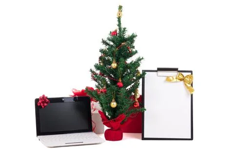 Decorated christmas tree, computer and gift list on white background Stock Photos