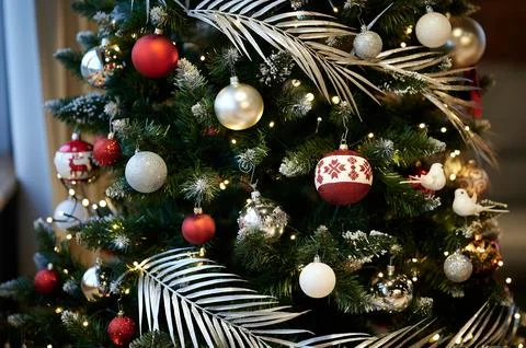 Decorated Christmas tree featuring red and white ornaments, silver baubles, a Fotos de archivo