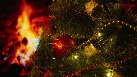Decorated Christmas tree in front of the fireplace with a burning fire. Stock Footage 286129262