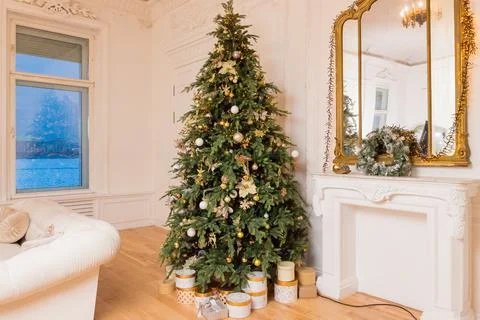 Decorated Christmas tree with golden patchwork ornament, gold balls and big gift Stock Photos