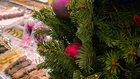 Decorated Christmas tree with red and purple ornaments near a market stall Stock Footage 297012298