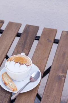 Decorated coffee with cookie and spoon on a wooden table. Close up. Stock Photos