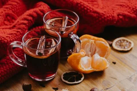 Decorated composition of mugs with mulled wine in knitted scarf, close up Stock Photos