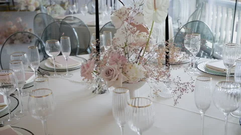 Decorated dinner table with a vase of roses, gypsophila and calla lilies  Stock Footage 131662534