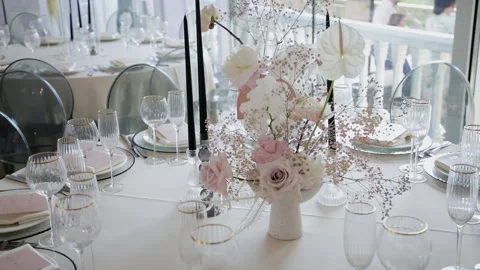 Decorated dinner table with a vase of roses, gypsophila and calla lilies  Stock Footage 131662662