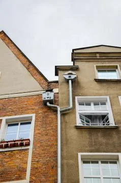 Decorated double metallic drainpipe of two houses on the wall of a building.  Stock Photos