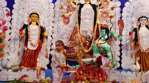 Decorated durga idol with kid folded-hand devotee at dussehra in day Stock Footage 314785969