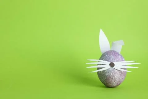 Decorated Easter egg and cute bunny's ears on color background. Space for tex Stock Photos