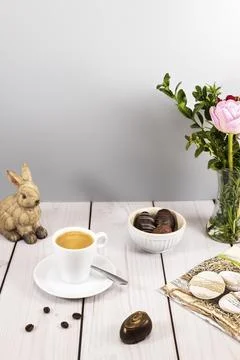 Decorated easter egg chocolates with espresso at set table Stock Photos