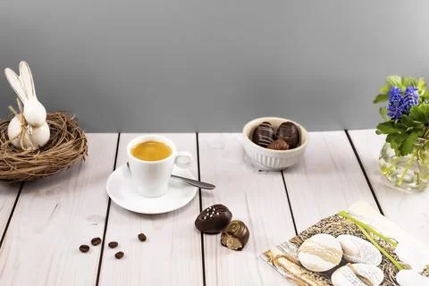 Decorated easter egg chocolates with espresso at set table Stock Photos