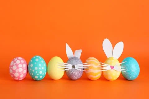 Decorated Easter eggs and cute bunny's ears on color background Stock Photos