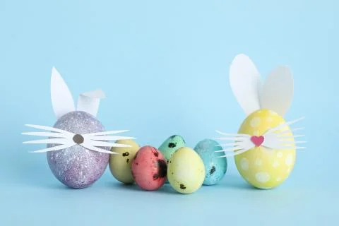 Decorated Easter eggs and cute bunny's ears on color background Foto stock