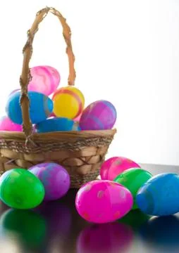 Decorated Easter eggs are on a table and in a basket. Stock Photos