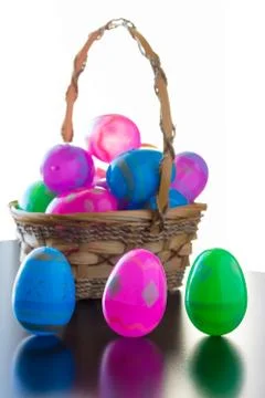 Decorated Easter eggs are on a table and in a basket. Stock Photos