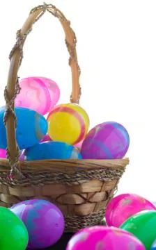 Decorated Easter eggs are on a table and in a basket. Stock Photos