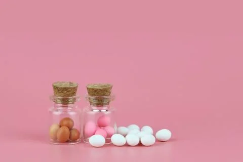 Decorated easter eggs in bottle with pink background Stock Photos