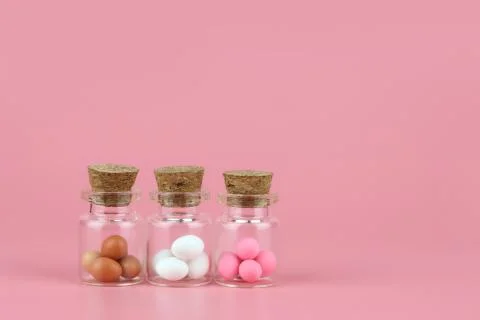 Decorated easter eggs in bottle with pink background Stock Photos