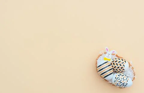 Decorated Easter eggs with Easter bunny lie in the basket on yellow backgroun 写真素材