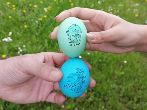 Decorated Easter eggs in hand of man and woman. The custom of tapping egg. Stock Photos