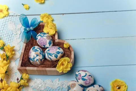 Decorated Easter eggs in heart shaped box. White lace, yellow flowers Stock Photos