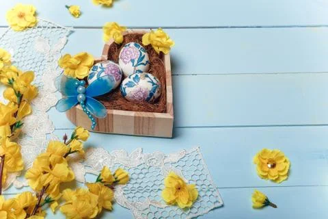 Decorated Easter eggs in heart shaped box. White lace, yellow  flowers Stock Photos