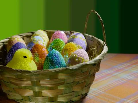 Decorated Easter eggs in a large basket on a festive background. Stock Photos