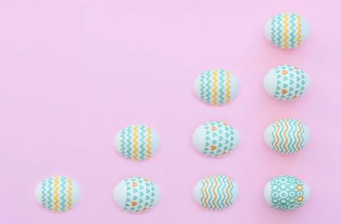 Decorated Easter eggs lie on the pink background. Happy Easter holiday concep Stock Photos