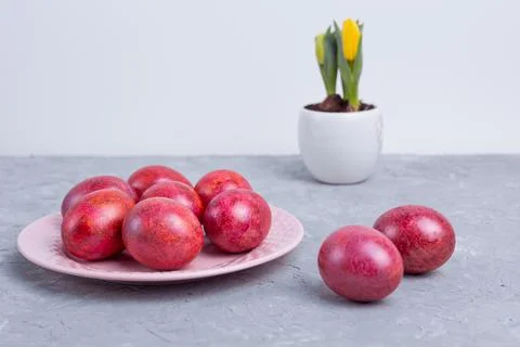 Decorated Easter eggs on pink ceramic plate and gray marble table Stock Photos