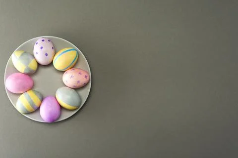 Decorated Easter eggs on a plate on a gray background with place for text. Vi Stock Photos