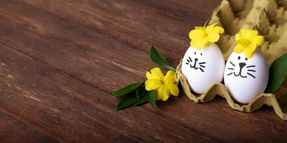 Decorated Easter funny eggs and cute yellow flowers around with empty space on 스톡 사진