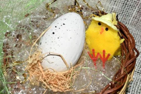 Decorated egg with chick inside a wicker basket 库存照片