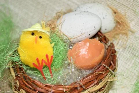 Decorated egg with chick inside a wicker basket 스톡 사진