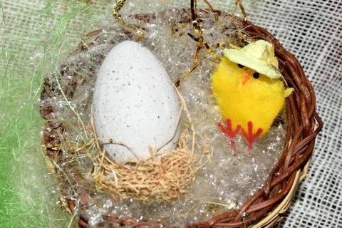 Decorated egg with chick inside a wicker basket 스톡 사진