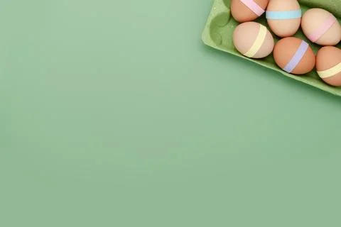 Decorated eggs in carton empty background. Fun Easter background Stock Photos