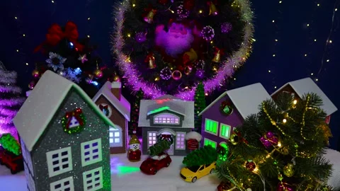 Decorated grey house rotating in front of a large decorated Christmas village Video stock 319896010