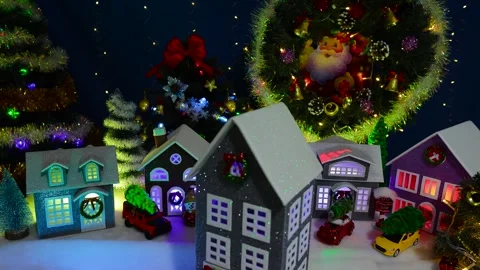 A decorated house spinning in front of a large decorated Christmas town Stock Footage 319896018