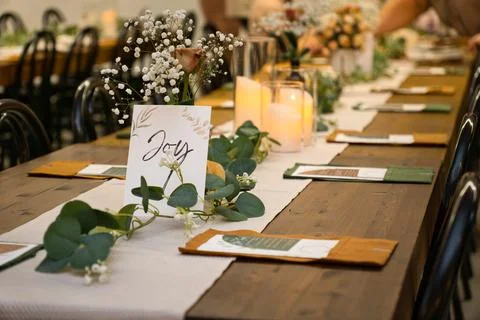Decorated long wooden table with flowers and candles for an event. Stock Photos
