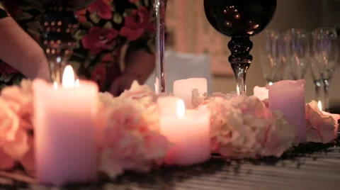 Decorated table with candles and decorations. A woman lights a candle Stock Footage 62677289