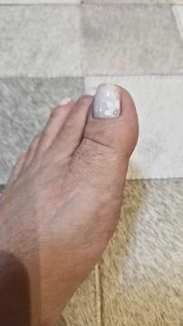 A decorated toenail on the carpet Stock Photos