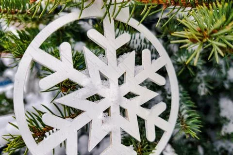 A decorated tree stands with a white snowflake ornament hanging from its bran Stock Photos