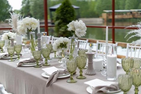 Decorated wedding table, white peonies and feathers. Chiavari chairs are at t Stock Photos