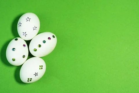 Decorated White Easter Eggs on Bright Green Paper Background Stock Photos