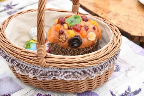 Decorated wicker Easter basket with Easter cake, painted eggs, treat Stock Photos